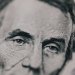 Closeup of male American president printed on five dollar bill and looking away pensively